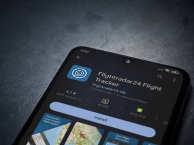 Lod, Israel - July 16,2023: Flightradar24 Flight Tracker app play store page on smartphone on a dark marble stone background. Top view flat lay with copy space.