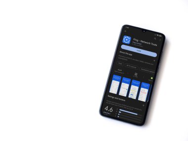 Lod, Israel - July 16,2023: Fing app play store page on smartphone on white background. Top view flat lay with copy space.