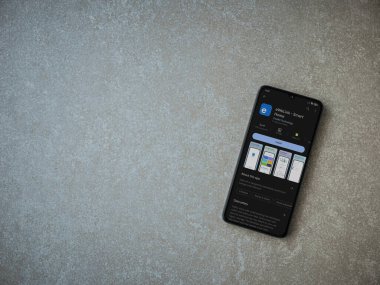 Lod, Israel - July 16,2023: eWeLink app play store page on smartphone on ceramic stone background. Top view flat lay with copy space.