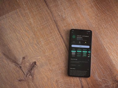 Lod, Israel - July 16,2023: Chat AI app play store page on smartphone on wooden background. Top view flat lay with copy space.