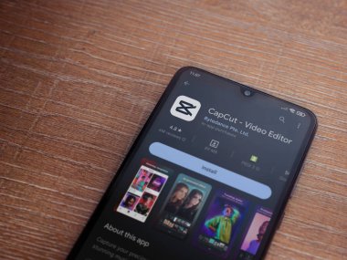 Lod, Israel - July 16,2023: CapCut app play store page on smartphone on wooden background.. Top view flat lay with copy space.