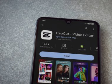 Lod, Israel - July 16,2023: CapCut app play store page on smartphone on ceramic stone background.. Top view flat lay with copy space.