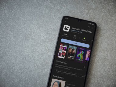 Lod, Israel - July 16,2023: CapCut app play store page on smartphone on ceramic stone background.. Top view flat lay with copy space.