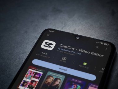 Lod, Israel - July 16,2023: CapCut app play store page on smartphone on a dark marble stone background. Top view flat lay with copy space.