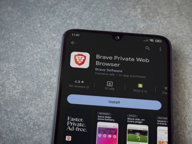 Lod, Israel - July 16,2023: Brave Private Browser app play store page on smartphone on ceramic stone background. Top view flat lay with copy space.