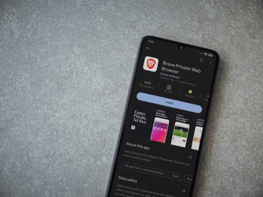 Lod, Israel - July 16,2023: Brave Private Browser app play store page on smartphone on ceramic stone background. Top view flat lay with copy space.