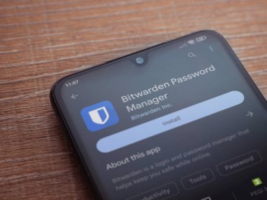 Lod, Israel - July 16,2023: Bitwarden Password Manager app play store page on smartphone on wooden background. Top view flat lay with copy space.