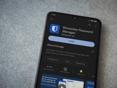 Lod, Israel - July 16,2023: Bitwarden Password Manager app play store page on smartphone on ceramic stone background. Top view flat lay with copy space.