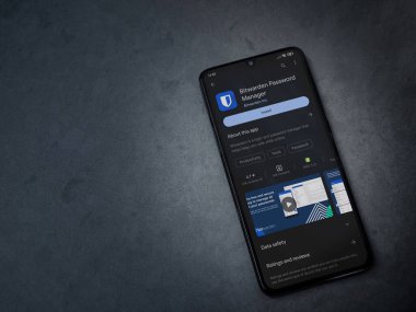 Lod, Israel - July 16,2023: Bitwarden Password Manager app play store page on smartphone on a dark marble stone background. Top view flat lay with copy space.
