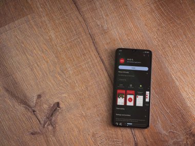 Lod, Israel - July 16,2023: Avis IL app play store page on smartphone on wooden background. Top view flat lay with copy space.