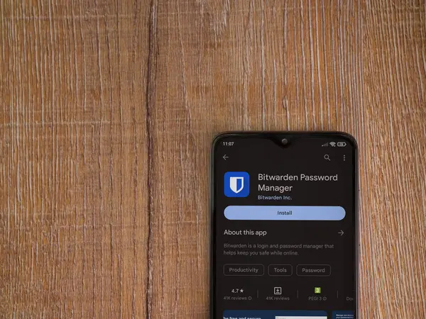 Lod, Israel - July 16,2023: Bitwarden Password Manager app play store page on smartphone on wooden background. Top view flat lay with copy space.
