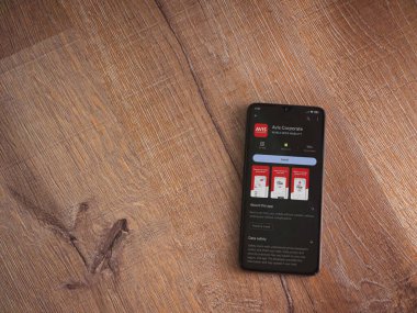 Lod, Israel - July 16,2023: Avis Corporate app play store page on smartphone on wooden background. Top view flat lay with copy space.