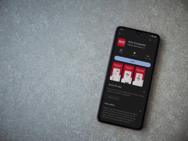 Lod, Israel - July 16,2023: Avis Corporate app play store page on smartphone on ceramic stone background. Top view flat lay with copy space.