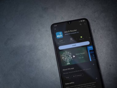 Lod, Israel - July 16,2023: ASUS Router app play store page on smartphone on a dark marble stone background. Top view flat lay with copy space.