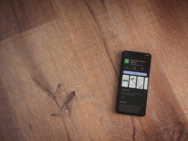 Lod, Israel - July 16,2023: AdGuard app play store page on smartphone on wooden background. Top view flat lay with copy space.