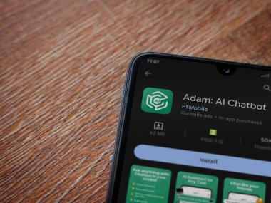 Lod, Israel - July 16,2023: Adam Ai app play store page on smartphone on wooden background. Top view flat lay with copy space.