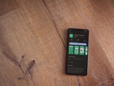 Lod, Israel - July 16,2023: Adam Ai app play store page on smartphone on wooden background. Top view flat lay with copy space.