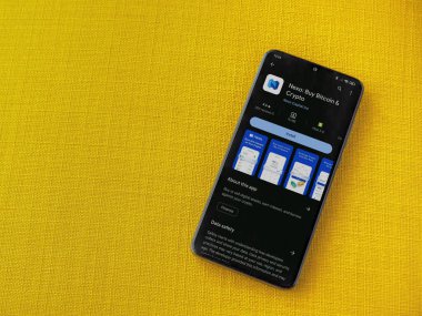 Lod, Israel - 16 Temmuz 2023: Nexo app oyun mağazası sayfası sarı kumaş arka planda akıllı telefon. Üst görünüm düzlüğü kopyalama alanı ile yatıyordu.