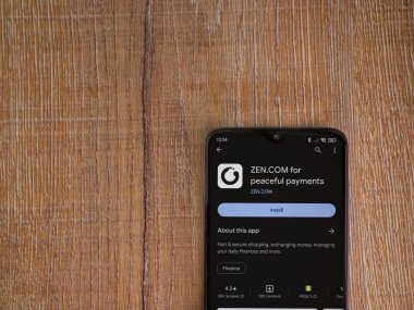 Lod, Israel - 16 Temmuz 2023: ZEN.COM uygulama oyun mağazası sayfası ahşap zemin üzerinde akıllı telefon. Üst görünüm düzlüğü kopyalama alanı ile yatıyordu.