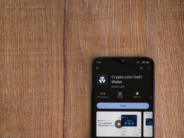 Lod, Israel - 16 Temmuz 2023: Crypto.com uygulama oyun mağazası sayfası ahşap zemin üzerinde akıllı telefon. Üst görünüm düzlüğü kopyalama alanı ile yatıyordu.