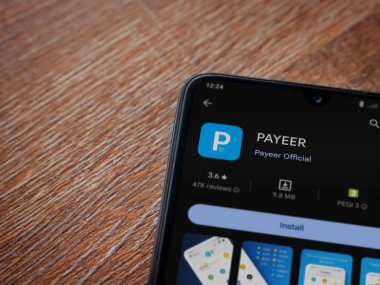 Lod, Israel - 16 Temmuz 2023: PaYEER uygulama oyun mağazası sayfası ahşap zemin üzerinde akıllı telefon. Üst görünüm düzlüğü kopyalama alanı ile yatıyordu.