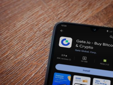 Lod, Israel - 16 Temmuz 2023: Gate.io uygulama oyun mağazası sayfası ahşap arka planda akıllı telefon. Üst görünüm düzlüğü kopyalama alanı ile yatıyordu.