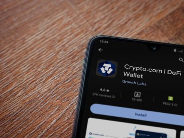 Lod, Israel - 16 Temmuz 2023: Crypto.com uygulama oyun mağazası sayfası ahşap zemin üzerinde akıllı telefon. Üst görünüm düzlüğü kopyalama alanı ile yatıyordu.