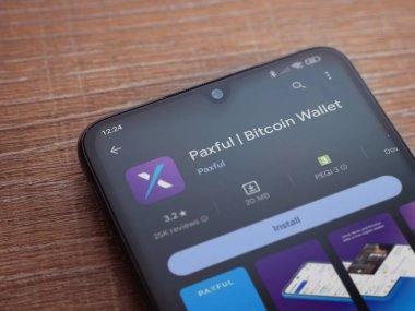 Lod, Israel - 16 Temmuz 2023: Ahşap arka planda akıllı telefon üzerine acınası bir uygulama oyun mağazası sayfası. Üst görünüm düzlüğü kopyalama alanı ile yatıyordu.