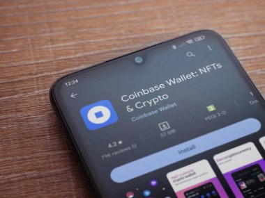 Lod, Israel - 16 Temmuz 2023: Cüzdan tabanı uygulaması oyun sayfası ahşap arka planda akıllı telefon. Üst görünüm düzlüğü kopyalama alanı ile yatıyordu.