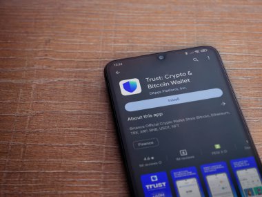 Lod, Israel - 16 Temmuz 2023: Cüzdan uygulaması oyun mağazası sayfası ahşap arka planda akıllı telefon. Üst görünüm düzlüğü kopyalama alanı ile yatıyordu.