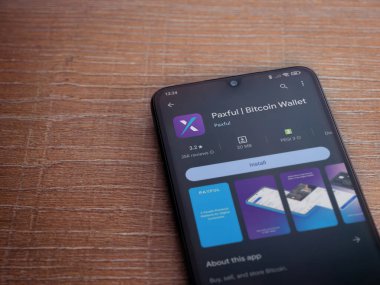 Lod, Israel - 16 Temmuz 2023: Ahşap arka planda akıllı telefon üzerine acınası bir uygulama oyun mağazası sayfası. Üst görünüm düzlüğü kopyalama alanı ile yatıyordu.