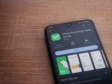 Lod, Israel - 16 Temmuz 2023: eToro uygulama oyun mağazası sayfası ahşap arka planda akıllı telefon. Üst görünüm düzlüğü kopyalama alanı ile yatıyordu.
