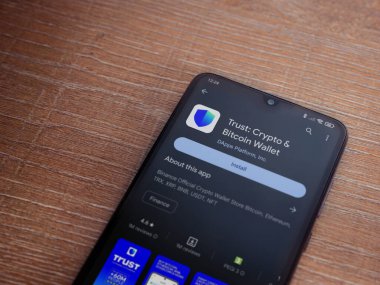 Lod, Israel - 16 Temmuz 2023: Cüzdan uygulaması oyun mağazası sayfası ahşap arka planda akıllı telefon. Üst görünüm düzlüğü kopyalama alanı ile yatıyordu.