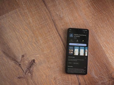 Lod, Israel - 16 Temmuz 2023: Ahşap arka planda akıllı telefon üzerine düzenli olarak uygulama oyun mağazası sayfası. Üst görünüm düzlüğü kopyalama alanı ile yatıyordu.
