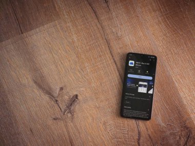 Lod, Israel - 16 Temmuz 2023: MEXC uygulama oyun mağazası sayfası ahşap zemin üzerinde akıllı telefon. Üst görünüm düzlüğü kopyalama alanı ile yatıyordu.