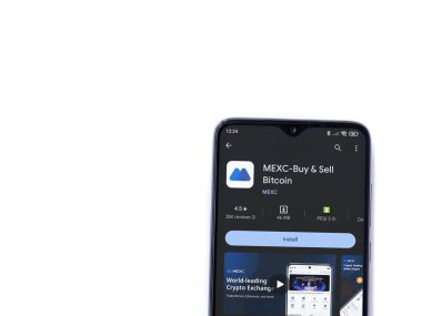 Lod, Israel - 16 Temmuz 2023: MEXC uygulama oyun mağazası sayfası beyaz arka planda akıllı telefon. Üst görünüm düzlüğü kopyalama alanı ile yatıyordu.