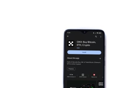 Lod, Israel - 16 Temmuz 2023: OKX uygulama oyun mağazası sayfası beyaz arka planda akıllı telefon. Üst görünüm düzlüğü kopyalama alanı ile yatıyordu.