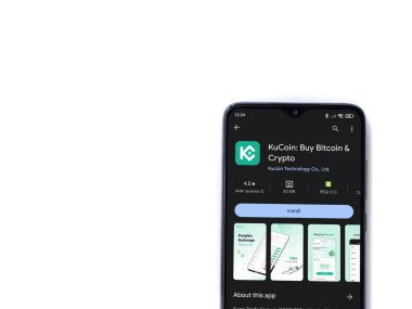 Lod, Israel - 16 Temmuz 2023: KuCoin uygulaması oyun mağazası sayfası beyaz arka planda akıllı telefon. Üst görünüm düzlüğü kopyalama alanı ile yatıyordu.