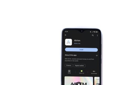 Lod, Israel - 16 Temmuz 2023: AirTM uygulama oyun mağazası sayfası beyaz arka planda akıllı telefon. Üst görünüm düzlüğü kopyalama alanı ile yatıyordu.