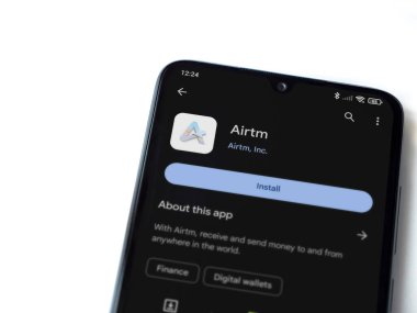 Lod, Israel - 16 Temmuz 2023: AirTM uygulama oyun mağazası sayfası beyaz arka planda akıllı telefon. Üst görünüm düzlüğü kopyalama alanı ile yatıyordu.
