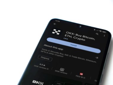 Lod, Israel - 16 Temmuz 2023: OKX uygulama oyun mağazası sayfası beyaz arka planda akıllı telefon. Üst görünüm düzlüğü kopyalama alanı ile yatıyordu.