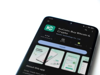 Lod, Israel - 16 Temmuz 2023: KuCoin uygulaması oyun mağazası sayfası beyaz arka planda akıllı telefon. Üst görünüm düzlüğü kopyalama alanı ile yatıyordu.