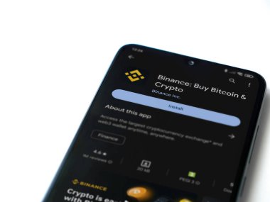 Lod, Israel - 16 Temmuz 2023: Binance uygulama oyun mağazası sayfası beyaz arka planda akıllı telefon. Üst görünüm düzlüğü kopyalama alanı ile yatıyordu.