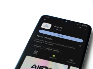 Lod, Israel - 16 Temmuz 2023: AirTM uygulama oyun mağazası sayfası beyaz arka planda akıllı telefon. Üst görünüm düzlüğü kopyalama alanı ile yatıyordu.