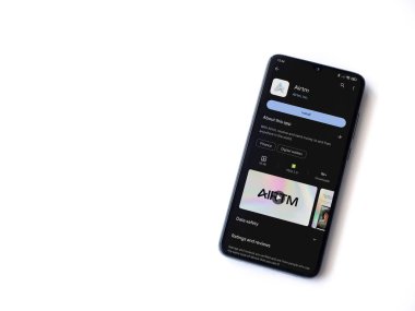 Lod, Israel - 16 Temmuz 2023: AirTM uygulama oyun mağazası sayfası beyaz arka planda akıllı telefon. Üst görünüm düzlüğü kopyalama alanı ile yatıyordu.