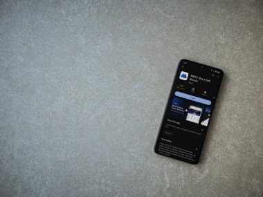 Lod, Israel - 16 Temmuz 2023: MEXC uygulama oyun mağazası sayfası seramik taş zemin üzerinde akıllı telefon. Üst görünüm düzlüğü kopyalama alanı ile yatıyordu.
