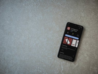 Lod, Israel - 16 Temmuz 2023: CoinWallet uygulaması seramik taş zemin üzerinde akıllı telefon oyun mağazası sayfası. Üst görünüm düzlüğü kopyalama alanı ile yatıyordu.