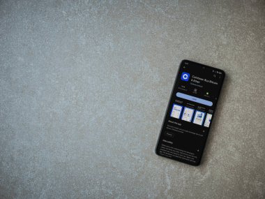Lod, Israel - 16 Temmuz 2023: Seramik taş zemin üzerinde akıllı telefon ile sikke bazlı uygulama oyun mağazası sayfası. Üst görünüm düzlüğü kopyalama alanı ile yatıyordu.