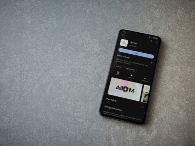 Lod, Israel - 16 Temmuz 2023: AirTM uygulama oyun mağazası sayfası seramik taş zemin üzerinde akıllı telefon. Üst görünüm düzlüğü kopyalama alanı ile yatıyordu.