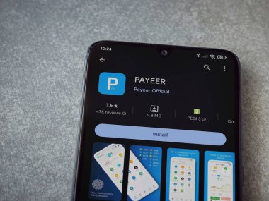 Lod, Israel - 16 Temmuz 2023: PaYEER uygulama oyun mağazası sayfası seramik taş zemin üzerinde akıllı telefon. Üst görünüm düzlüğü kopyalama alanı ile yatıyordu.